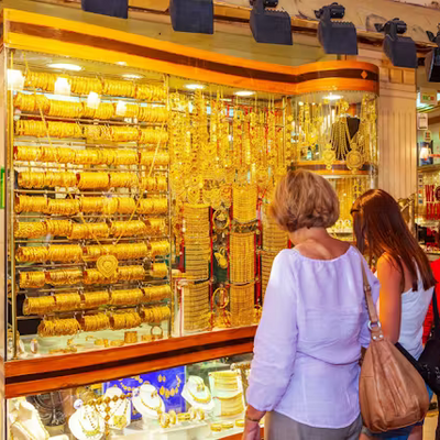 People looking at gold jewelry display in a store