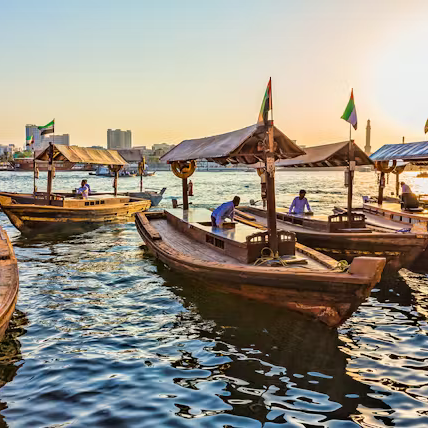 Traditional boats on a waterway with people and buildings in the background