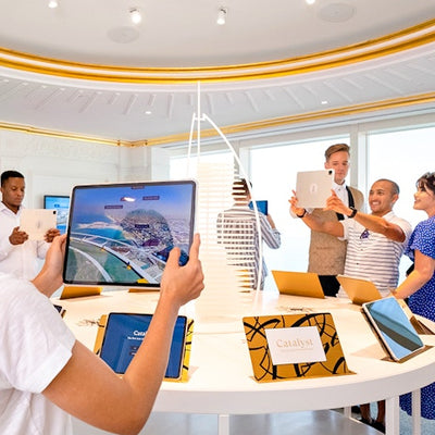 Group of people in a modern office setting using tablets.